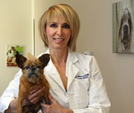 Photo of Christi Warren, veterinary ophthalmologist, holding a dog.